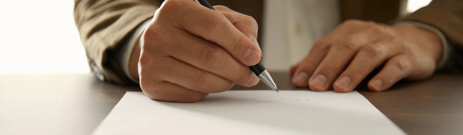 Online tanfolyamok – kéz tollal ír egy üres papírlapra